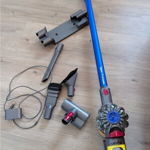 Dyson cordless vacuum with blue wand and gray accessories